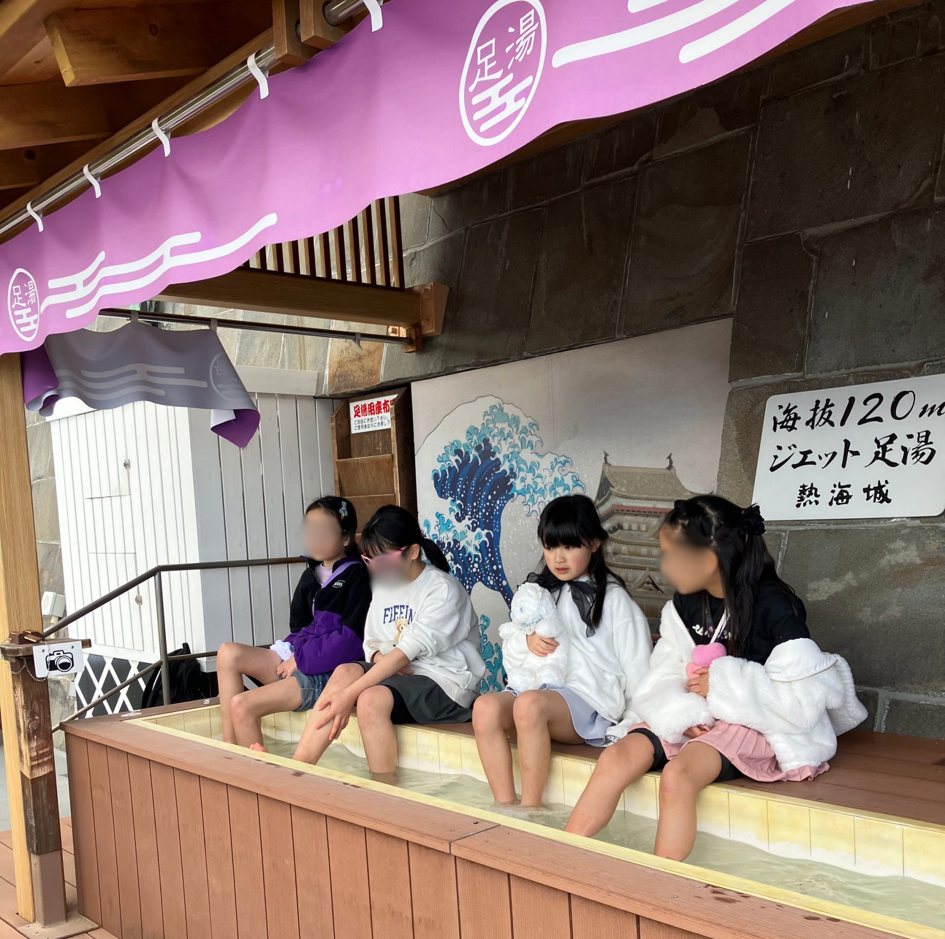 熱海城の海抜120mにあるジェット足湯に足を浸けながらリラックスする子どもたちの様子