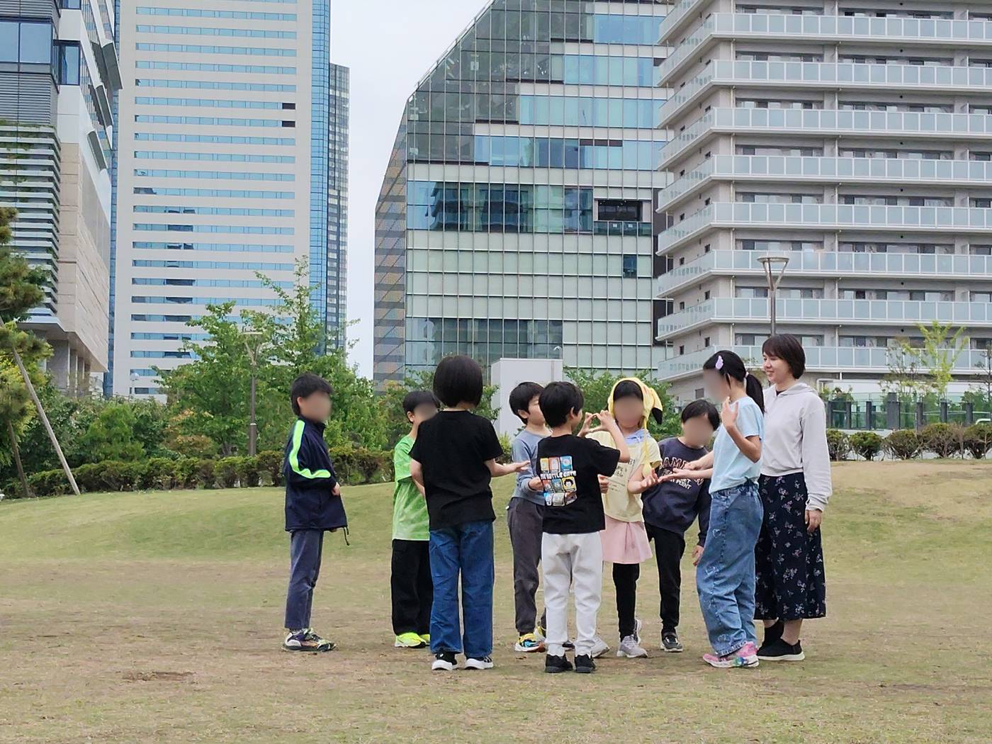 東京湾を望む豊洲ぐるり公園の芝生で遊ぶaini schoolの子どもたち