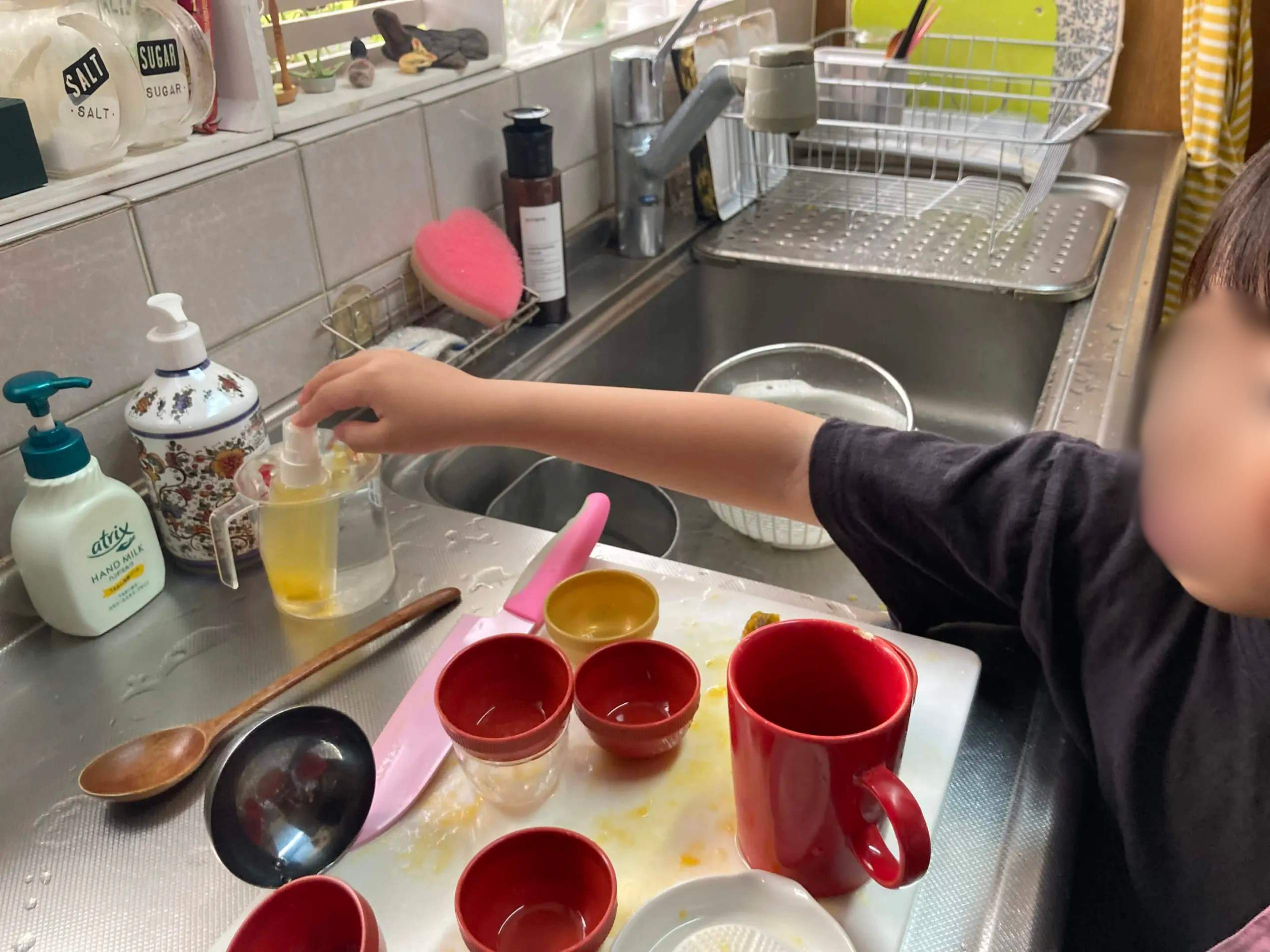 計量カップを使って梅スプレーの材料を丁寧に量る子どもたち