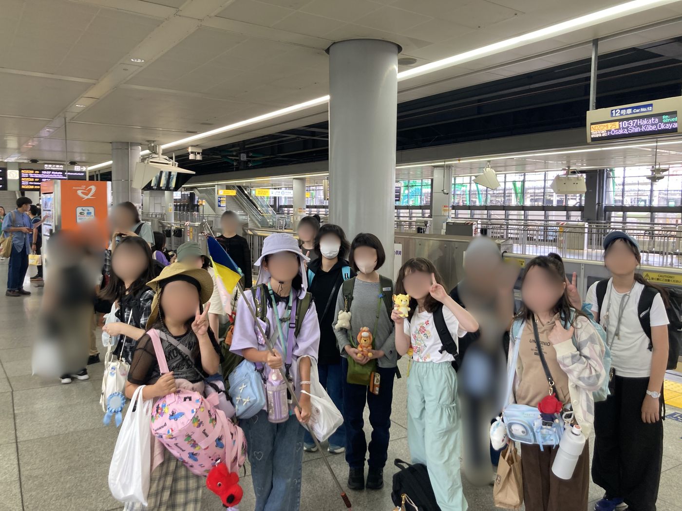 品川駅の新幹線ホームに集まったaini schoolの生徒たち、手作りの旗も見えます