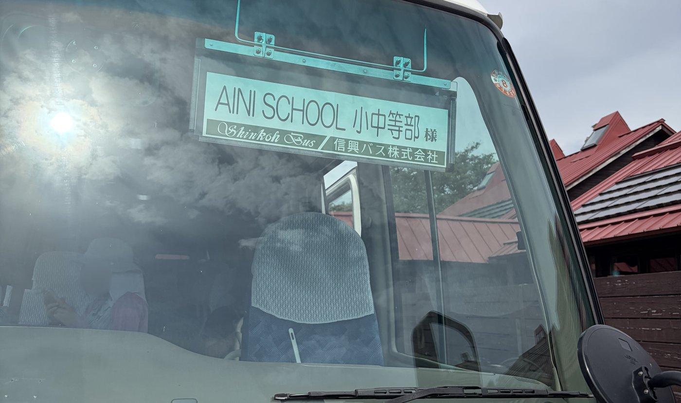 AINI SCHOOL小中等部様と書かれたマイクロバスの行き先表示板