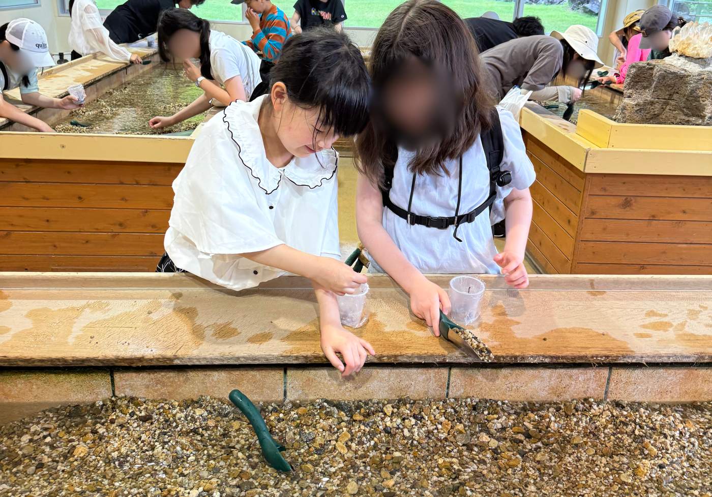 奇石博物館の砂場で宝石探しに集中するaini schoolの生徒たち